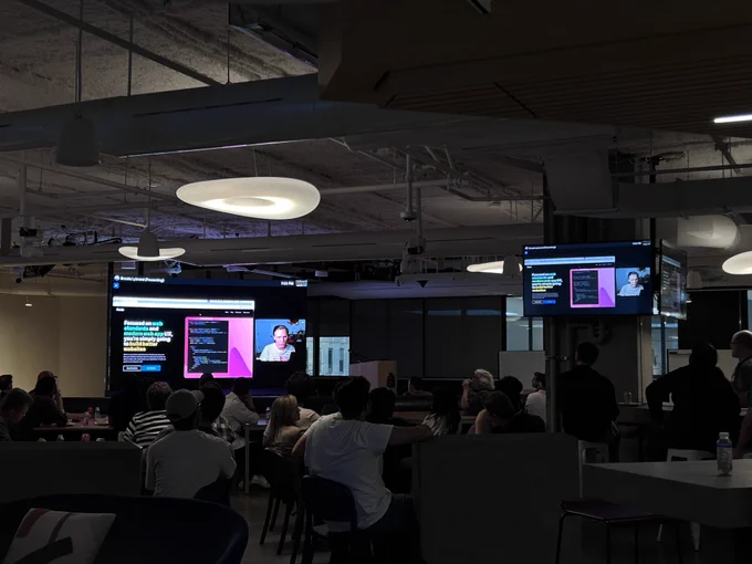 Room full of developers watching a presentation streamed live from Austin, Texas or a large screen!