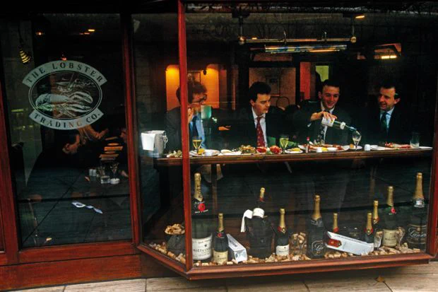 Four associates celebrate a successful day's business by treating themselves to a lunchtime bottle of white wine