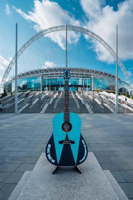 A bespoke personalised Taylor Swift guitar is pictured in front of the stadium and the iconic arch. 