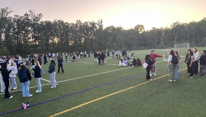 Class of 2025 seniors in the field with classmates as the sun comes up.