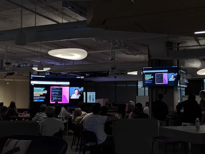 Room full of developers watching a presentation streamed live from Austin, Texas or a large screen!