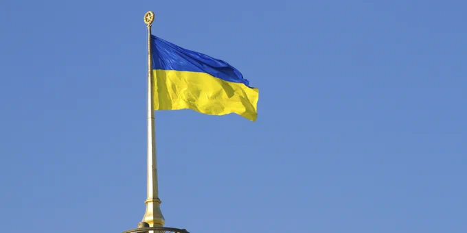 A flag of Ukraine against a blue sky