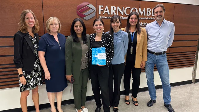 Filomena Tassi and Sonia Sidhu standing in front of the Farncombe Farncombe Family Digestive Health Research Institute with Farncombe faculty and members.