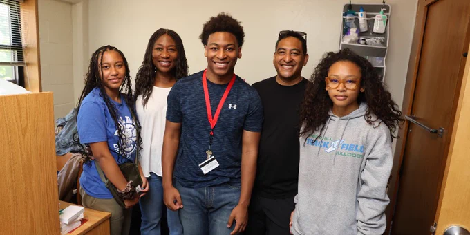 Five individuals posing for a photo in an RPI dorm room.