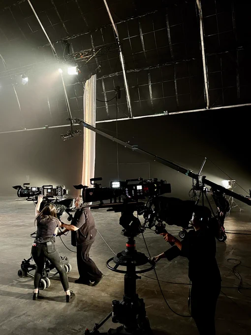 Two television cameras and a jib being operated by camera crew.