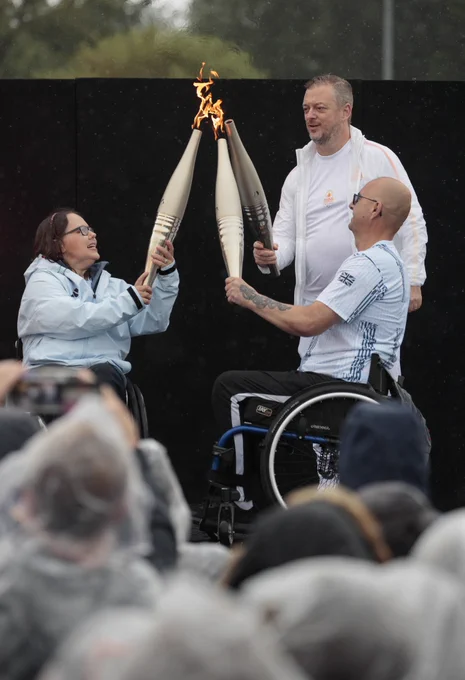 Helene Raynsford, Andrew Parsons and Gregor Ewan light the Paralympic flame at Stoke Mandeville