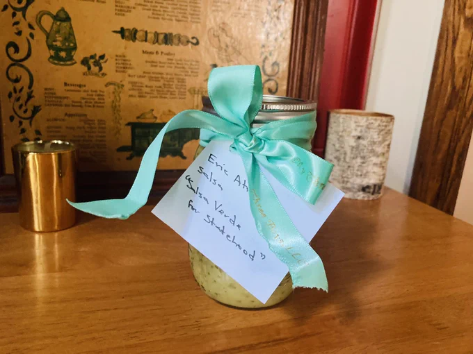 A jar of homemade Salsa Verde for Statehood with a mint green ribbon.