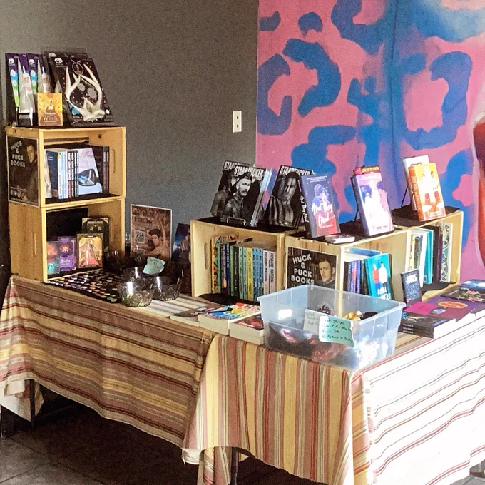 Two tables in a l-shape with books displayed.