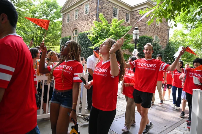 Students wave flags in the pre-rade