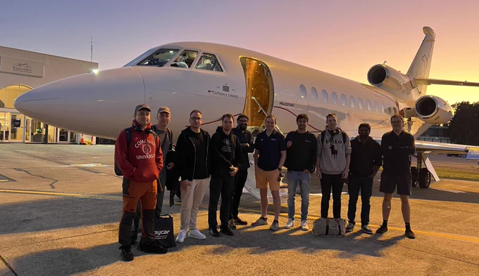 The reentry science team early in the morning at Sydney airport, ready for the test flights. We see ten people in front of the plane and the pilot in the cockpit.