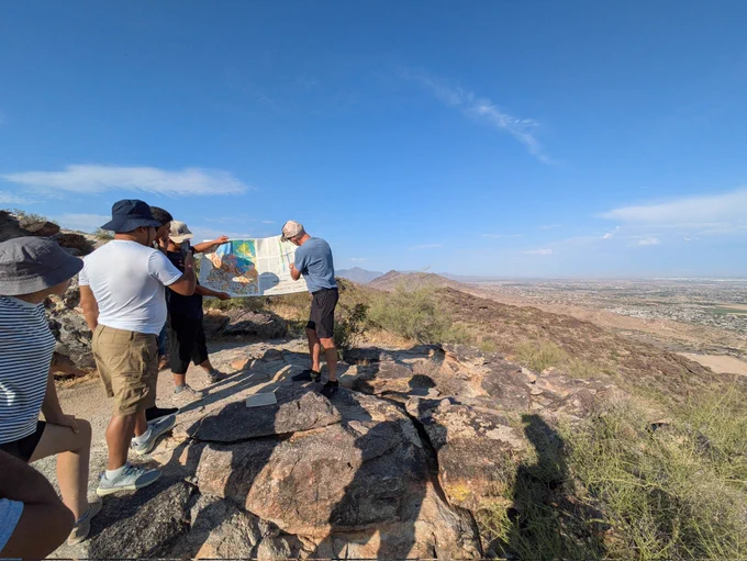 Geologists looking at a geological map on top of a mountain 