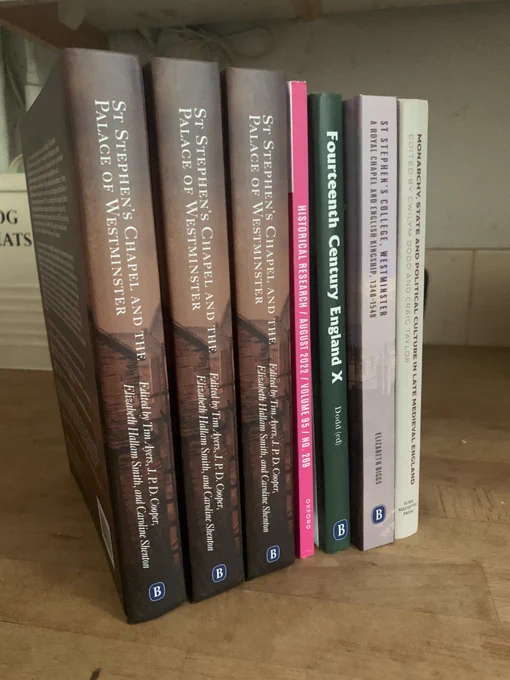 Seven books on a wooden countertop.