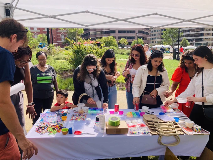 A bustling table with beaded bracelet craft.