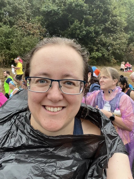 Beth is a white woman wearing glasses and a black bin bag.