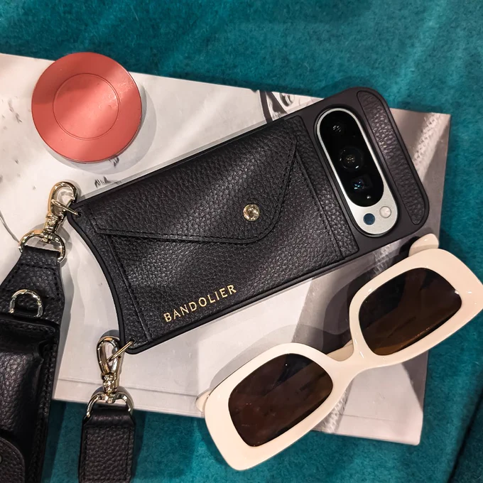 Wintergreen Pixel 9 in a Bandolier phone case next to a pair of sunglasses. 