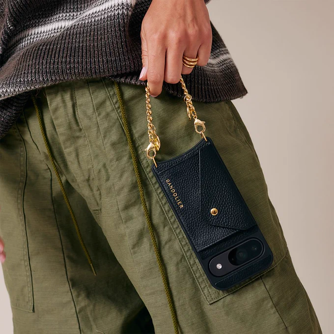 A person holding an Obsidian Pixel 9 in a Charm Wristlet Bandolier phone case.