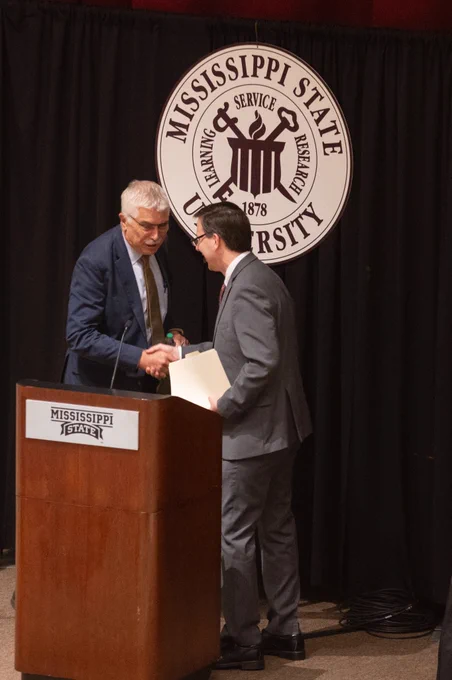 Dr. Robert Bertram shaking Dr. Mark Lawrence's hand