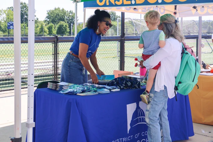 A DCPS staff member passes out resources to a DCPS family.