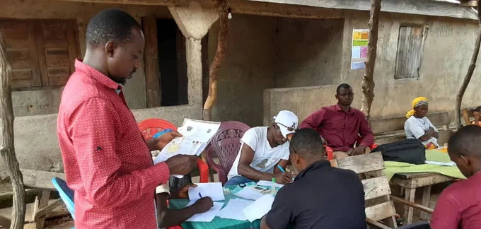 Photograph of people completing paperwork in a rural healthcare setting.