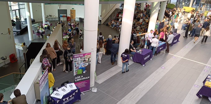 Library stand by the amphitheatre full of people at the welcome talk