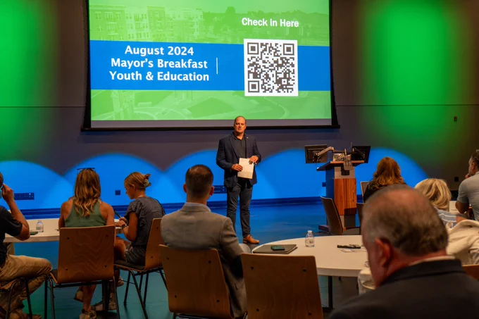 Scott Fadness welcoming the group to the breakfast in the City Hall Theater