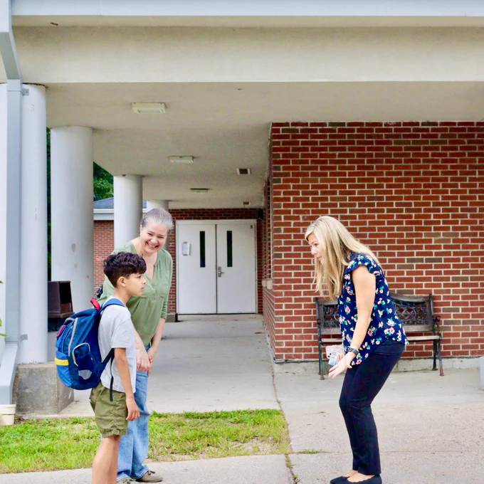 Director of Student Services Brittany Hawkins gleefully greets a student and caregiver outside Ashland Middle School