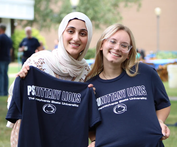 Two students pose with Penn State t-shirts