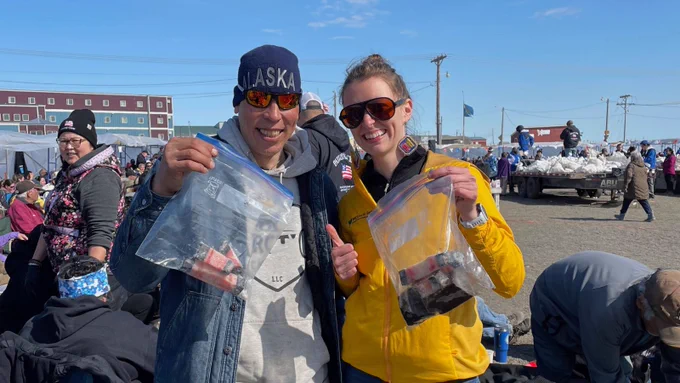 Local resident Dale Brower and Dr. Michelle Johannsen (One Health Coordinator for Arctic Beringia) enjoying maktak at the first Nulukataq (Whaling Festival) of the season in which community members come together to share and celebrate the harvest of whale meat. Sharing is the overriding spirit of the event; different cuts of the whale are given priority to be shared with elders, whaling crew members, and the broader community.  