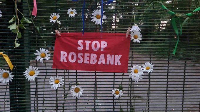 'Stop Rosebank' banner surrounded by daisies on the gate of the Horse Hill oil production site in Surrey
