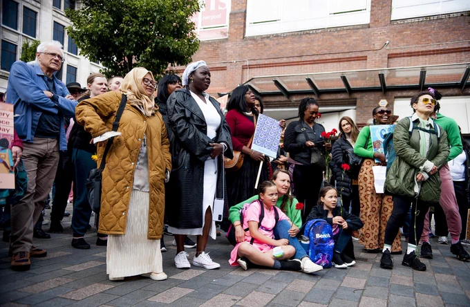 Diverse group of people watching something in a public street