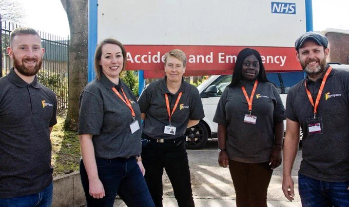 Five Navigators from our Oasis Navigator service stand in front of an A&E sign