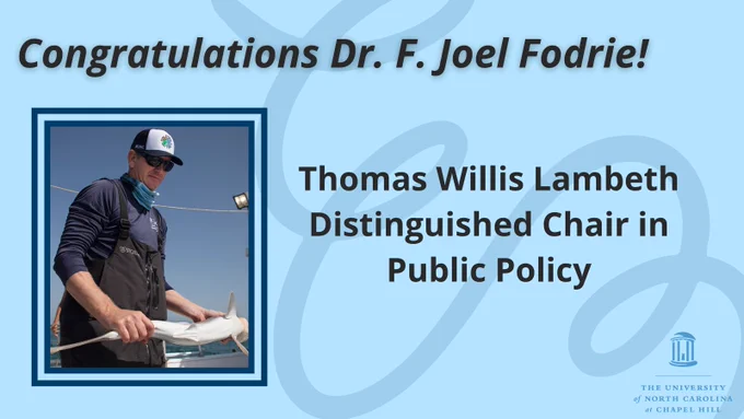 Picture of Dr. Joel Fodrie holding a shark with surrounding text that reads, Congratulations Dr. F. Joel Fodrie! Thomas Willis Lambeth Distinguished Chair in Public Policy