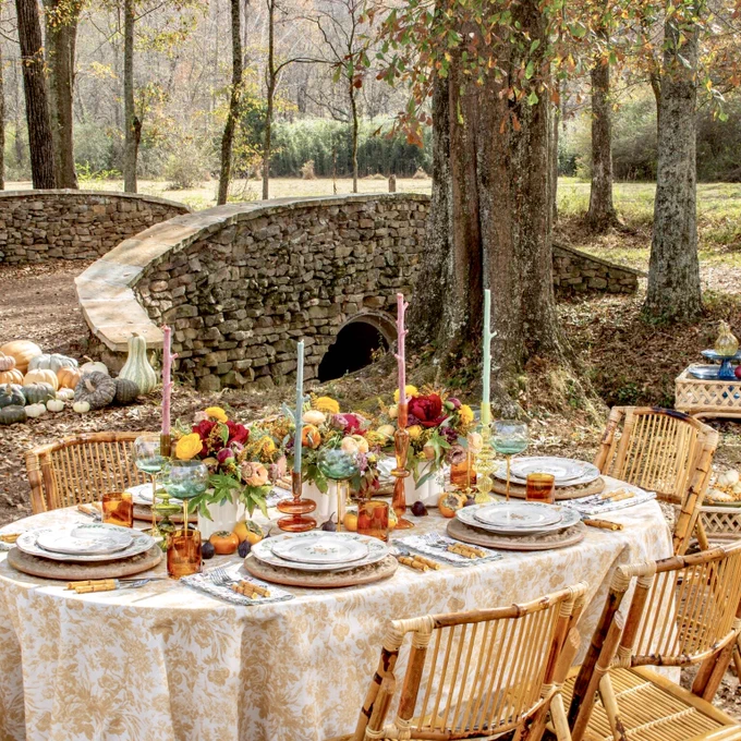 Second: An alfresco fall table setting with multicolored taper candles, amber glassware, and plenty of flowers.
