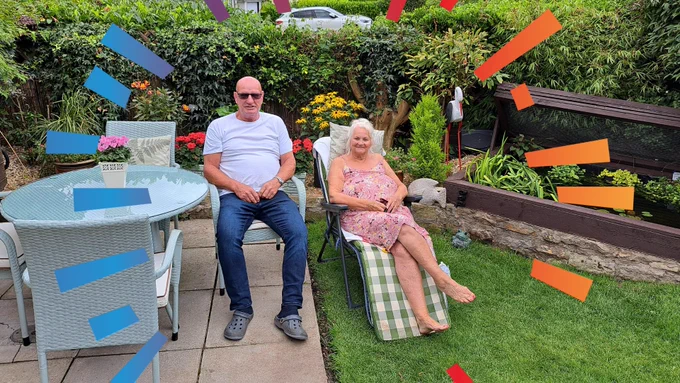 Photo of Mr and Mrs Beecroft sat on recliners in their garden. Both are smiling.