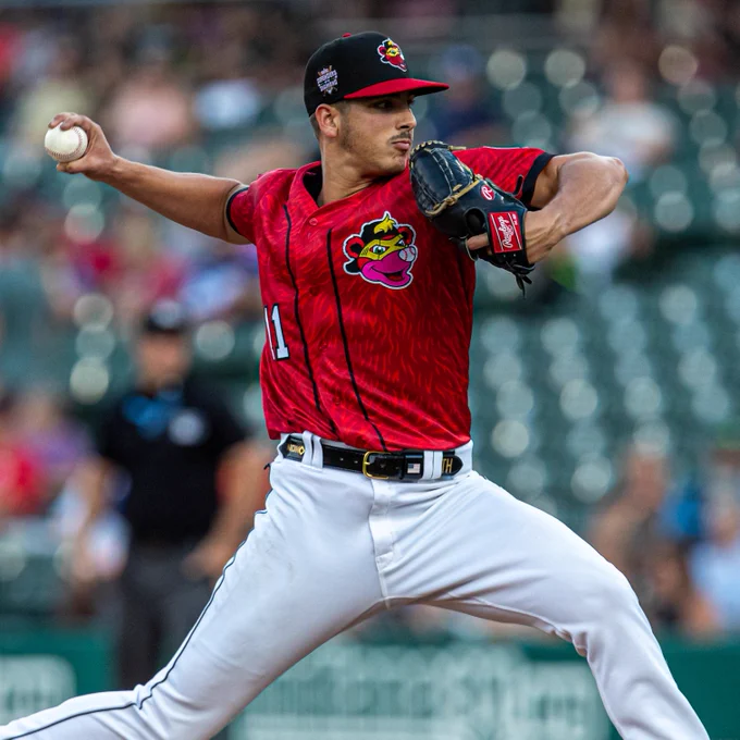 Thomas Harrington winds up to throw a pitch in a red Indianapolis uniform
