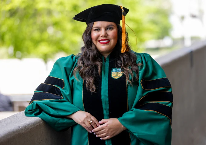 Rush nursing alum Delilah Flexas in regalia smiling proudly.