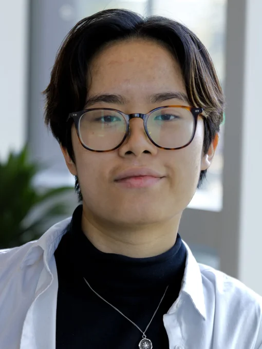 Chloe Nguyen | Systems Design Engineering wearing a turtleneck with an overshirt and smiling at the camera.