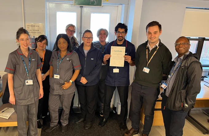 Nine healthcare colleagues holding a certificate