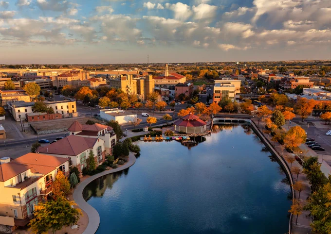 Aerial of Downtown Pueblo, Colorado during autumn with a lake in the foreground.