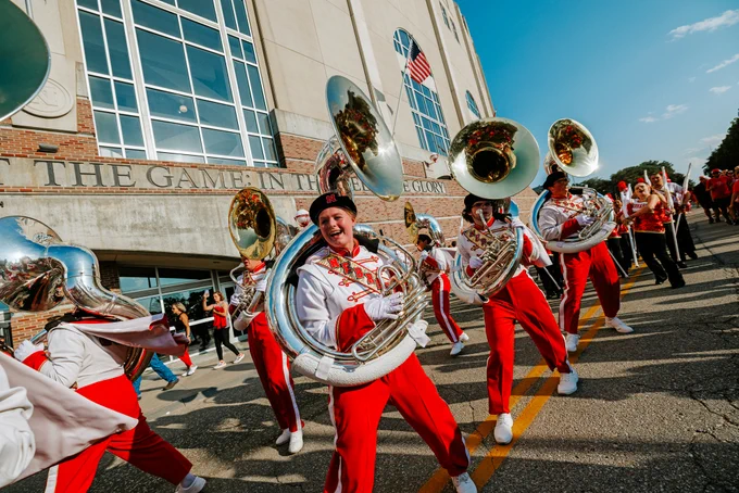 The band performs as they move down the street outside of Memorial Stadium