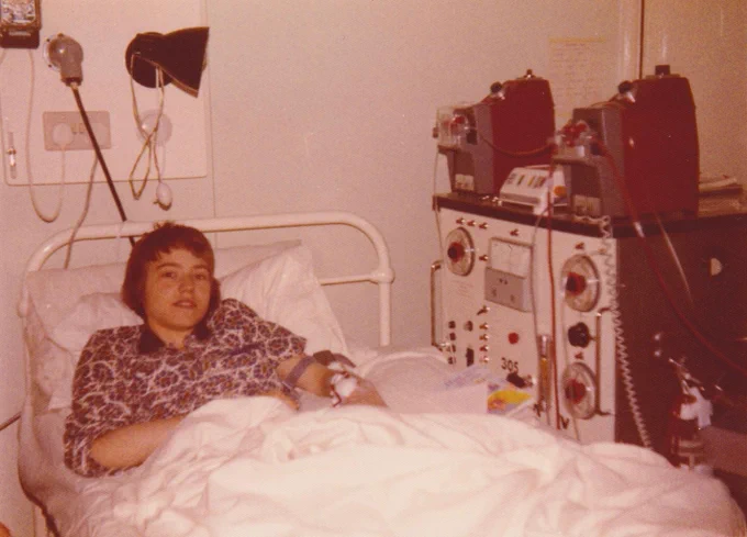 A 70's photograph of Mike in a hospital bed connected to dialysis machines.