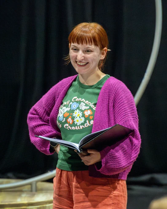 A woman with folder in hand smiling