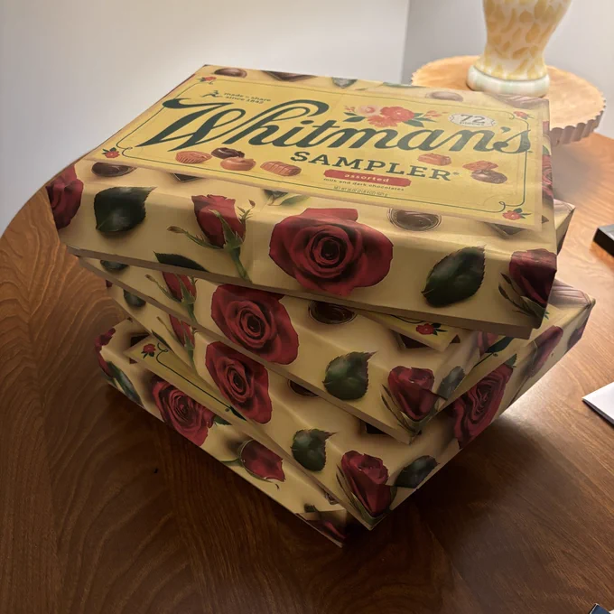 Four boxes covered in a large photo of a Whitman’s sampler box.