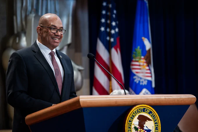 U.S. Marshals Service Director Ronald L. Davis stands before a podium ready to address the crowd of attendees. 