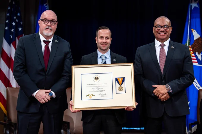 United States Marshals Service Director Ronald L. Davis (right) and Deputy Director Mark Pittella (left) present Chief Deputy U.S. Marshal Mathew Silverman (center) with the Distinguished Service Award. 