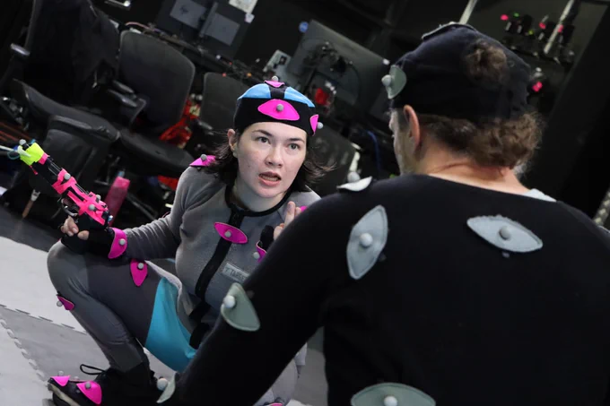 Mocap actor looking menacingly at another actor, brandishing a gun prop