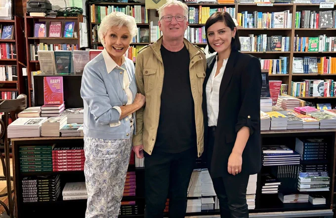 Angela Rippon, Colin Bateman and Annabel Scholey stand together in a book shop 
