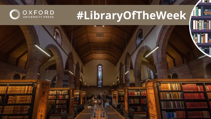 Interior of a library in a gothic church building. Book stacks and stained glass windows.
