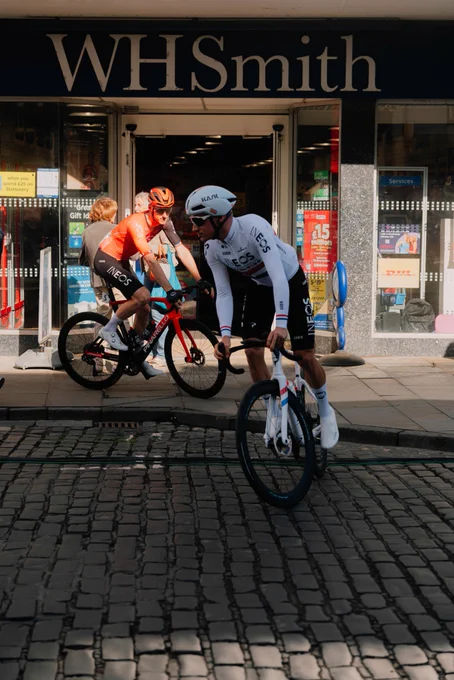 Ethan Hayter and Connor Swift ride past a WH Smith store ahead of stage one of the Tour of Britain. 