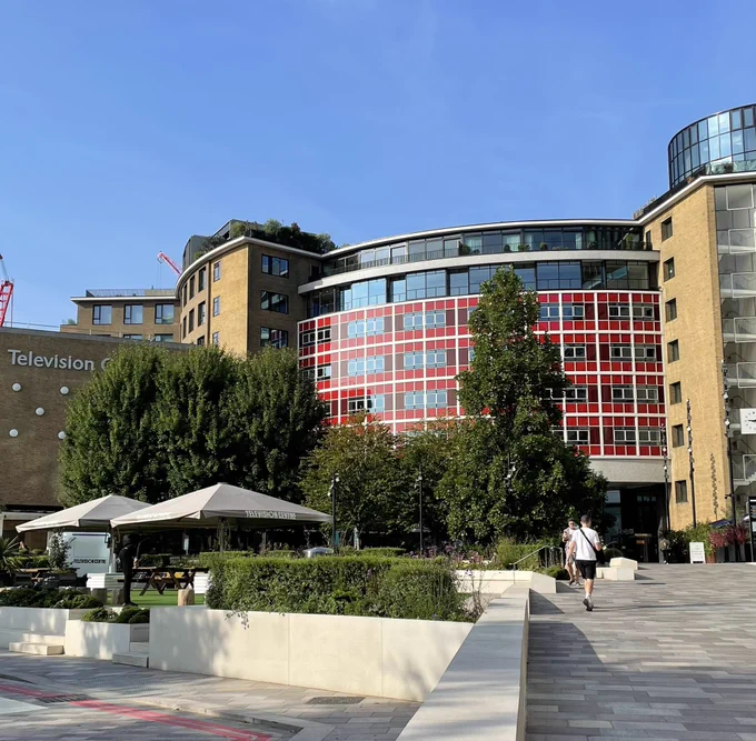 The exterior of Television Centre on a sunny day, against a bright blue sky.